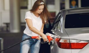 Mulher a abastecer o carro. Crédito: Freepik