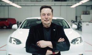 Elon Musk à frente de um Tesla.