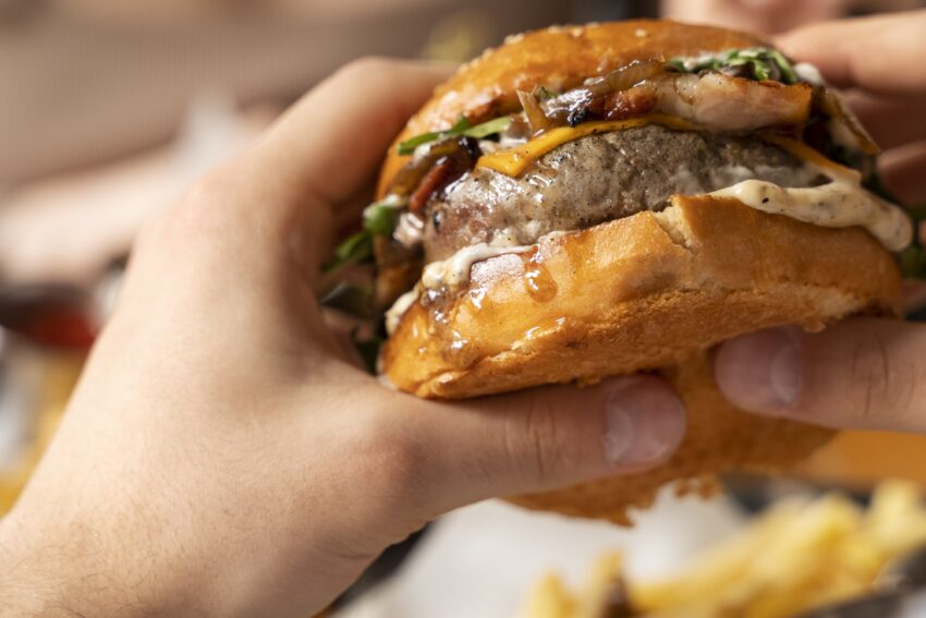 Comer um hambúrguer. Crédito: Freepik