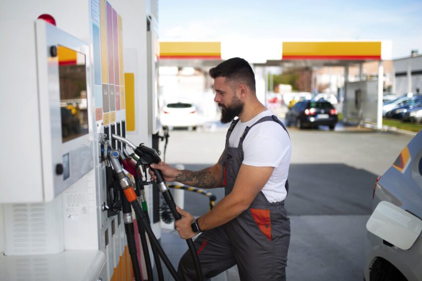 Homem a abastecer o carro num posto de combustível.