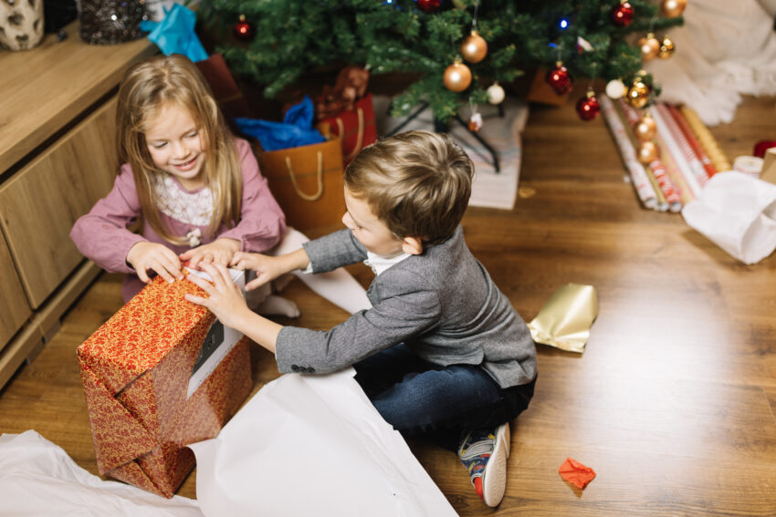 Crianças a abrir prendas de Natal. Crédito: Freepik