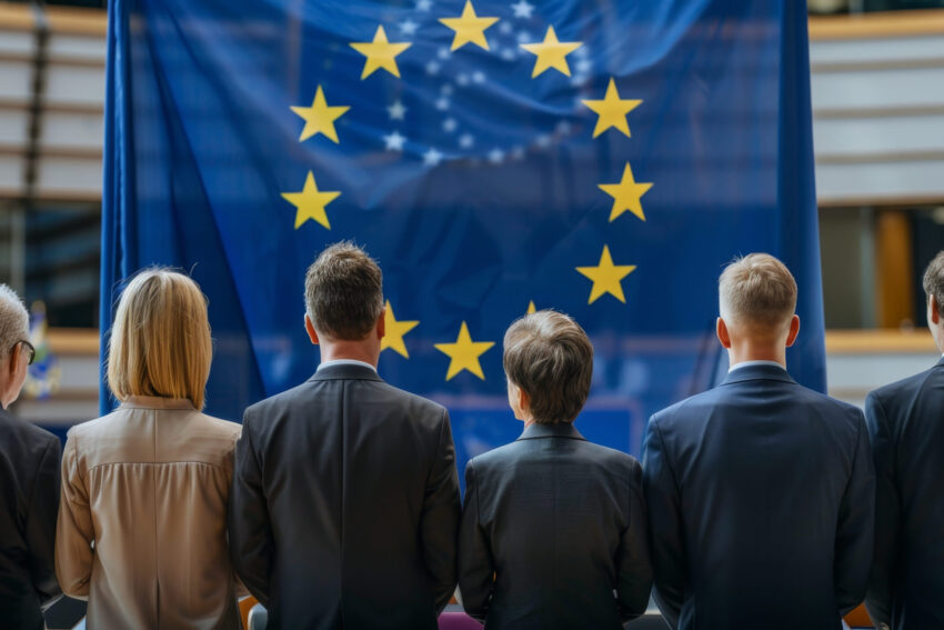 Pessoas de costas a olhar para bandeira da União Europeia. Crédito: Freepik