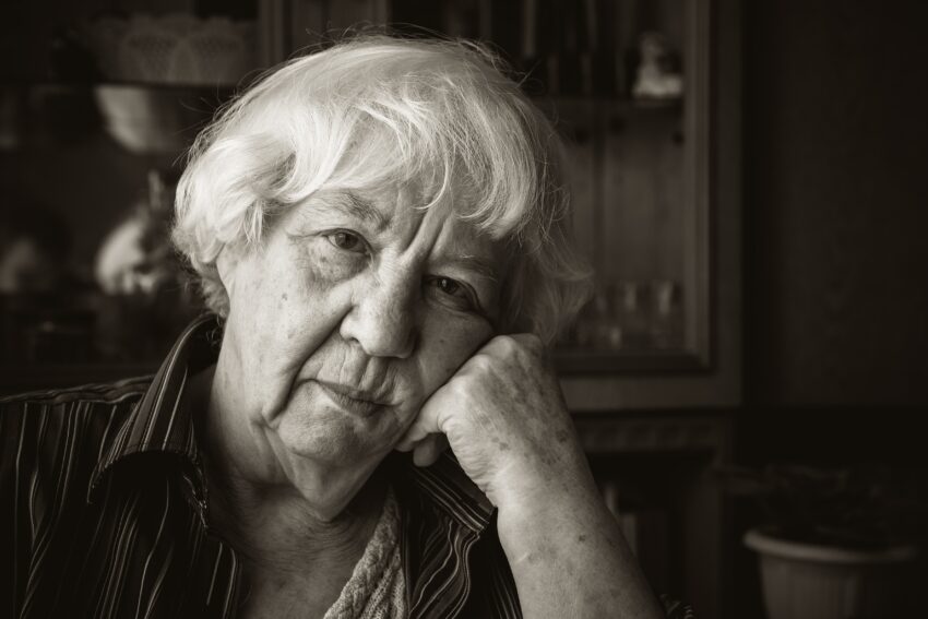 Mulher com a cabeça apoiada na mão. Crédito: Freepik