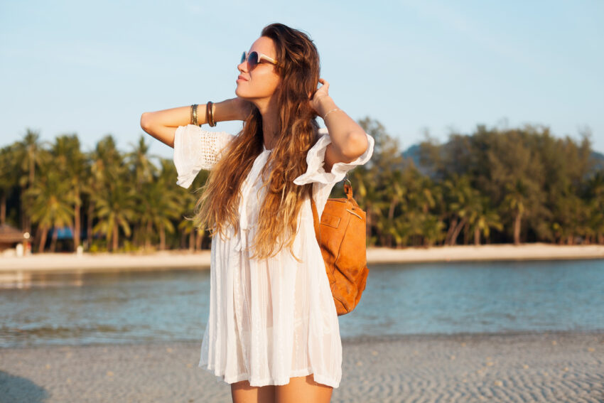 Rapariga numa praia tropical. Crédito: Freepik