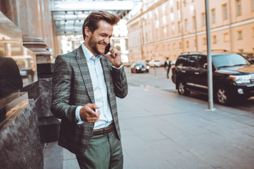 Homem de fato na rua a falar ao telefone. Crédito: Freepik