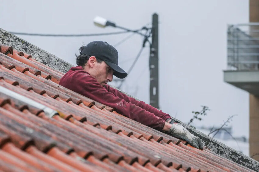 Publicitário a arranjar telhados. Crédito: Foto Carlos Barroso - Expresso | DR