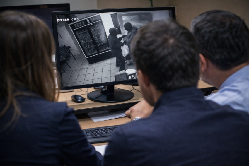 Observar imagens de assalto. Crédito: Foto AI