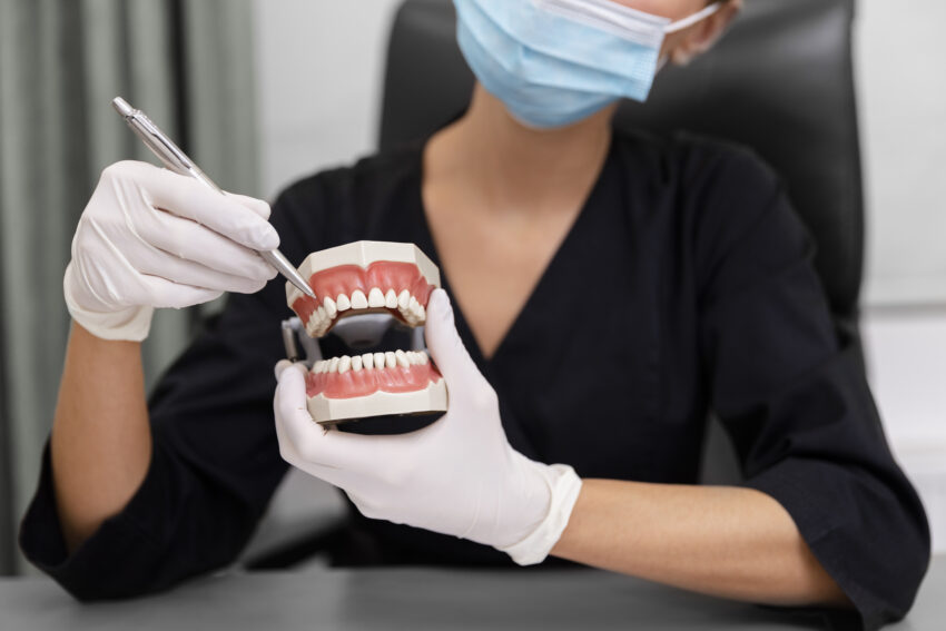 Dentista com uma prótese na mão.
