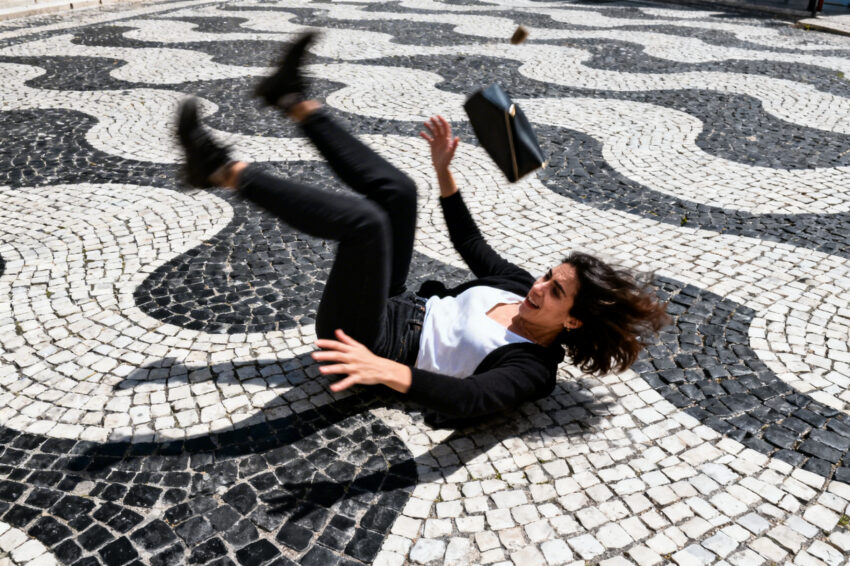 Mulher escorrega na calçada portuguesa.