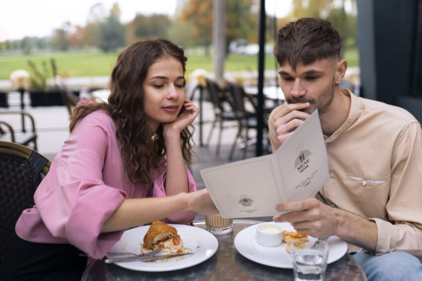 Casal no restaurante a ver o menu.
