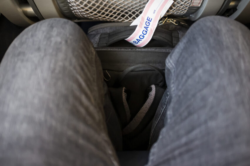 Mochila debaixo do assento do avião.