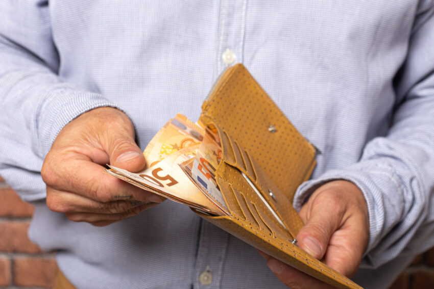 Homem a tirar dinheiro da carteira.