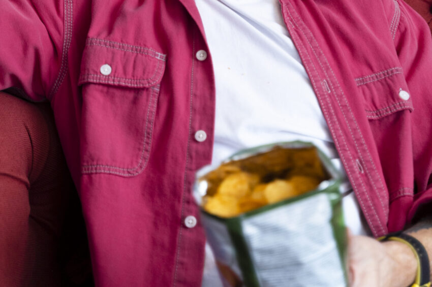 Homem a comer batatas fritas.