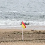Muitos banhistas não reparam nas bandeiras com riscas vermelha e amarela que se colocam aos pares nas praias: conheça o significado