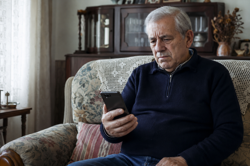 Homem a segurar telemóvel. Crédito: Foto AI