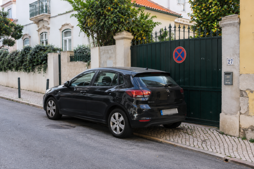 Carro estacionado à frente de um portão. Crédito: POSTAL AI – imagem gerada por IA