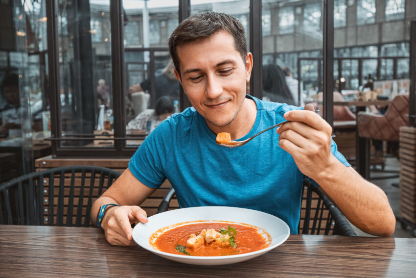 Homem a comer gaspacho. Crédito: Freepik